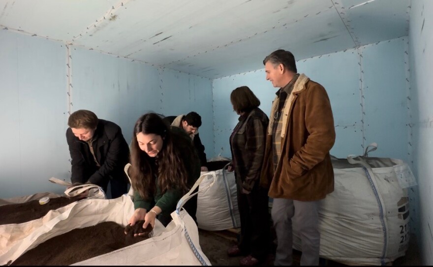 Soil Food owners and family members examine worm castings.