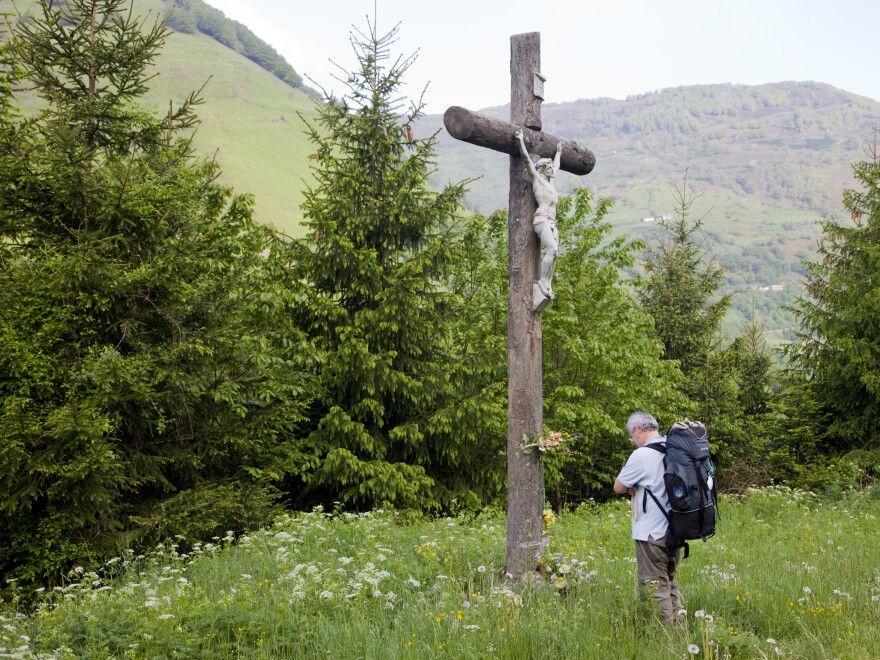 A pilgrim prays before a crucifix in Somport, France, along the Way of St. James. Last year, nearly 200,000 pilgrims walked the journey.