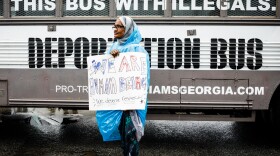 Amina Osman protests Georgia state Sen. Michael Williams's "Deportation Bus" that reads "Fill this bus with illegals." She has been a resident of Clarkston, Ga. for nine years and is a refugee from Somalia.
