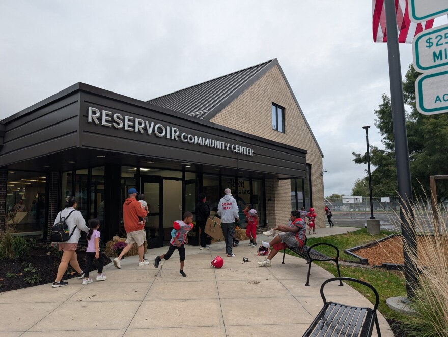 Kids put on football gear outside Reservoir Community Center. 