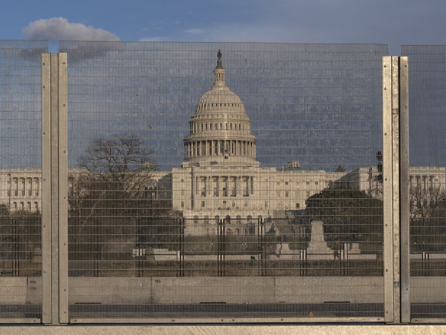 A section of fencing blocks the Capitol grounds at sunset on Monday. [Jacquelyn Martin / AP]