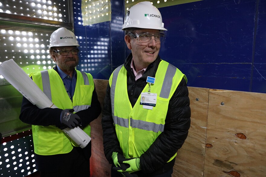 Ralph Pennino, the chair of surgery at Rochester Regional Health, and Kevin Casey, the president of Rochester General Hospital, ride an elevator to the top of the construction site at Rochester Regional's new center for critical care.