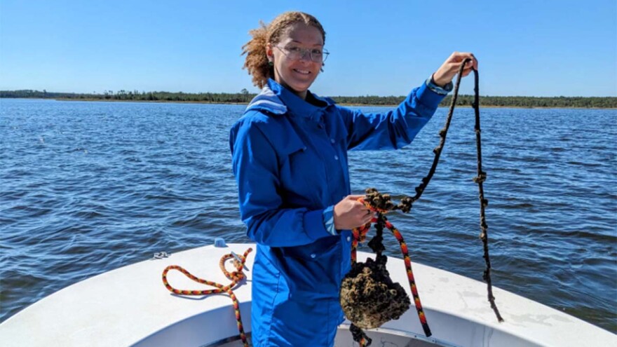 Rebecca Ruiz was recruited at N.C. State University as part of a new oyster restoration program. During a boat trip, she helped collect barnacle-laden items like this buoy and other instruments. (Sophie Mallinson/WUNC)