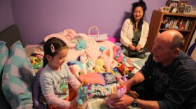 Former state lawmaker Kay Bounkeua takes a break from her work as her daughter Ryla Bounkeua plays with Kay's stepdad Jeffrey Strong in Rio Rancho, N.M, March 13.