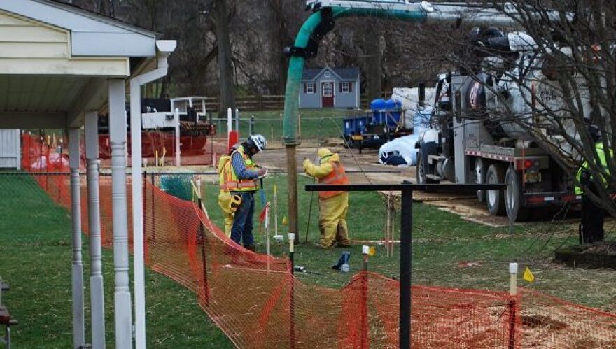 In this photo from May 2018, pipeline workers probe the ground on Lisa Drive in West Whiteland Township where sinkholes have developed as a result of the Mariner East 2 construction. (Jon Hurdle/StateImpact Pennsyvlvania)