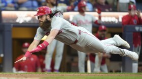 Philadelphia Phillies' Brandon Marsh leaps to score on an RBI double hit by Harrison Bader during the eighth inning of a baseball game against the Milwaukee Brewers, Monday, Sept. 1, 2025, in Milwaukee. (AP Photo/Kayla Wolf)