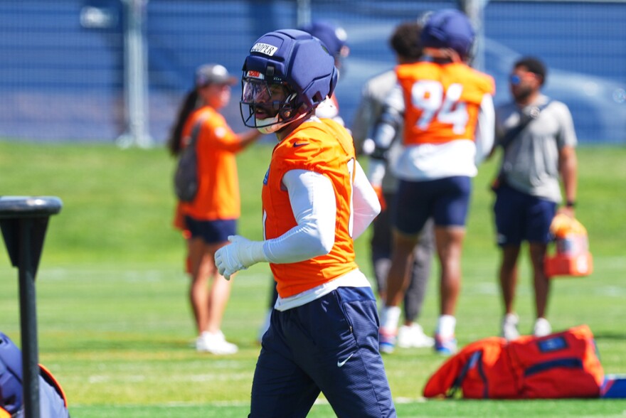 Denver Broncos linebacker Jonathon Cooper wears an orange jersey and blue helmet.