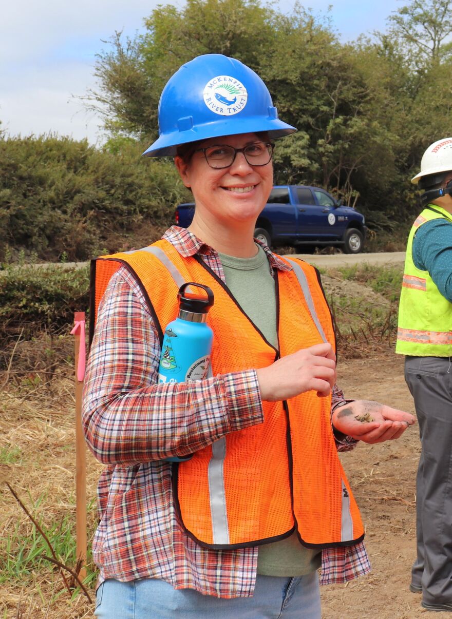 Woman in hardhat and construction vest.