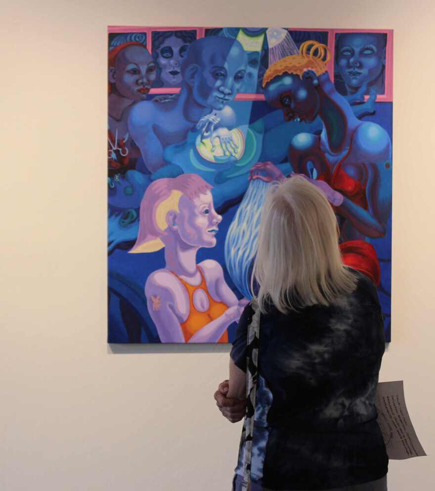 Viewer regards Delgado painting in Alliance for the Arts main gallery.