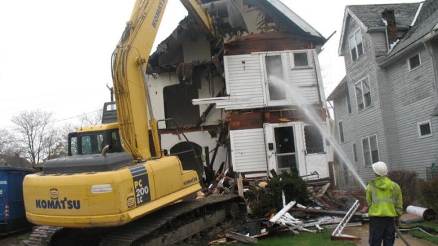 Cuyahoga Land Bank workers demolish a foreclosed Cleveland home in 2012. [Brian Bull / ideastream]