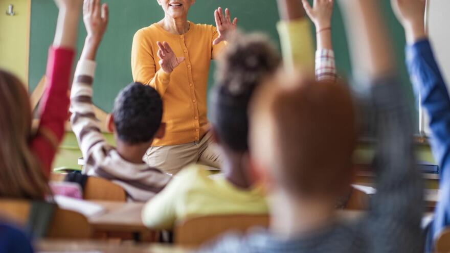 teacher with kids raising their hands