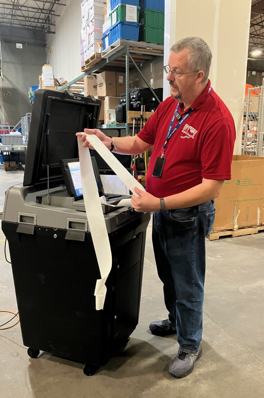 Scott County elections manager James Martin looks over a tape of ballot results from a voting machine during testing in Eldridge Oct. 8, 2026.
