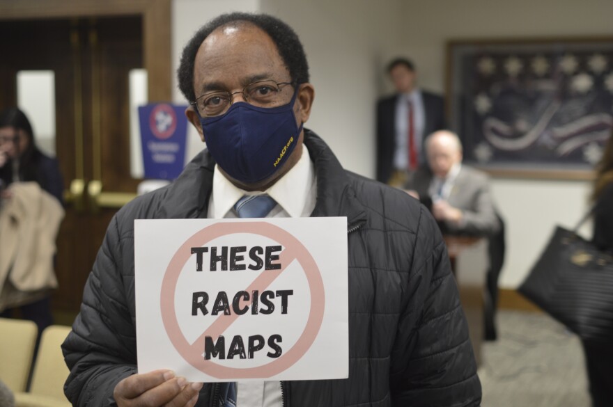 Middle Tennessee NAACP Vice President holds up a sign reading "Stop These Racist Maps" in the Senate Judiciary Committee as they take vote on district maps that have only gotten approval from the Republican Party.