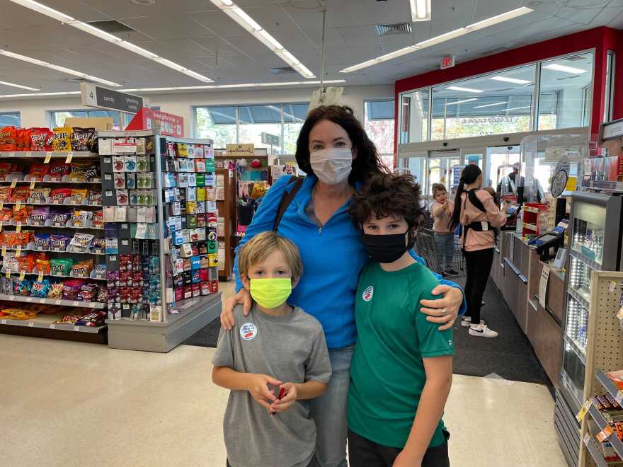 Brothers Eli and Ari Paddleford of Concord standing with their mom Karen Craver at the local Walgreens after getting vaccinated. The two boys are wearing stikers that read "I got the COVID-19 vaccine." 