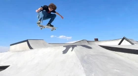 A skateboarder in the air above a ramp