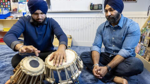 Talvinder Singh watches as his son, Ranveer, plays the tabla at the Gurdwara Guru Nanak Darbar in Medford, Mass. (Robin Lubbock/WBUR)