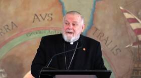 A Catholic archbishop speaks at a podium 