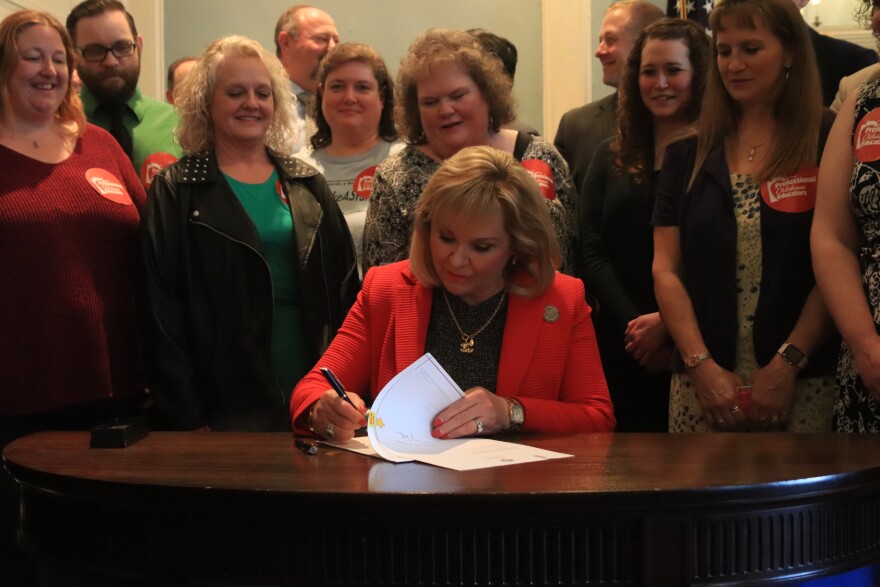 Flanked by teachers from the Professional Oklahoma Educators organization, Governor Mary Fallin signs a new teacher pay raise into law. March 29, 2018. 