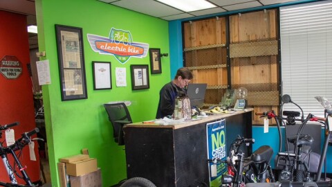 The Electric Bike Shop owner Mike Majors stands behind his desk Monday, Nov. 17, 2025, at 5704 Broadway in Sacramento.