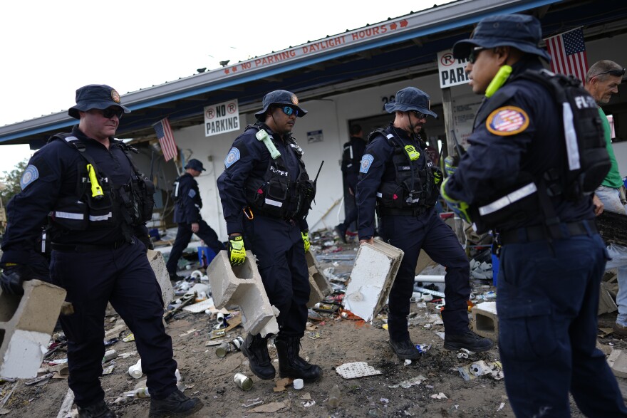 Members of Florida Task Force 1 urban search and rescue team assist the storm damaged business The Marina with moving and piling debris, in Horseshoe Beach, Fla., Thursday, Aug. 31, 2023, one day after the passage of Hurricane Idalia.