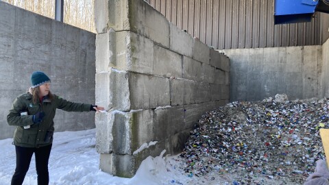 Lindsey Walker, head of recycling outreach and market development for Emmet County's recycling program, points to a pile of crushed glass that will later be picked up and taken to Ohio. From there, it's cleaned and recycled into fiberglass insulation and other products. (Photo: Ellie Katz/IPR News)