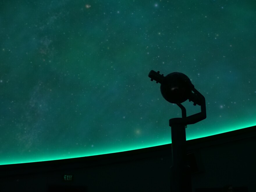 The star ball stands at the center of the planetarium in front of a display from the facility's digital projectors.