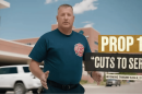 A men wearing a shirt with a logo of a fire department stands in front of a building. Words are superimposed over the image reading, "Prop 1 'Cuts to services' Wyoming Tribune Eagle, 7/31/26."