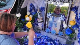 Egda Lee sets up an altar centered around a picture of the Virgin Mary which she carried with her when she crossed the U.S. border in 1984 pregnant with her son Neri Flores, as Nicaraguan parishioners of St. John Bosco Catholic Church celebrate the Dec. 8 feast of the Immaculate Conception, Sunday, Dec. 7, 2025, in Miami. (AP Photo/Rebecca Blackwell)