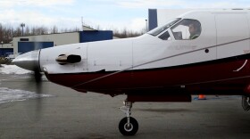 A man sits in the cockpit of a small plane.