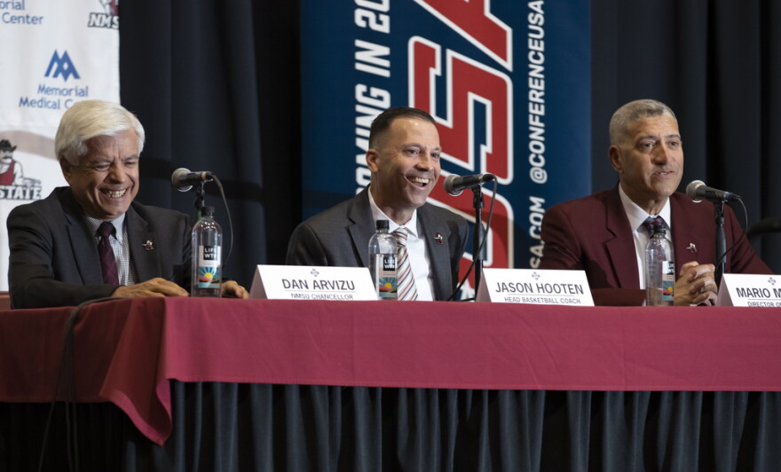 Newly appointed New Mexico State NCAA college basketball coach Jason Hooten, center, is flanked by school chancellor Dan Arvizu, left, and athletics director Mario Moccia during his introduction event in Las Cruces, N.M., Sunday, March 26, 2023. (AP Photo/Andres Leighton)