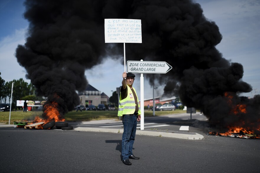 A protester holds a banner as people gather Thursday in Saint-Nazaire, in western France, to demonstrate against the government's proposed changes to labor law.