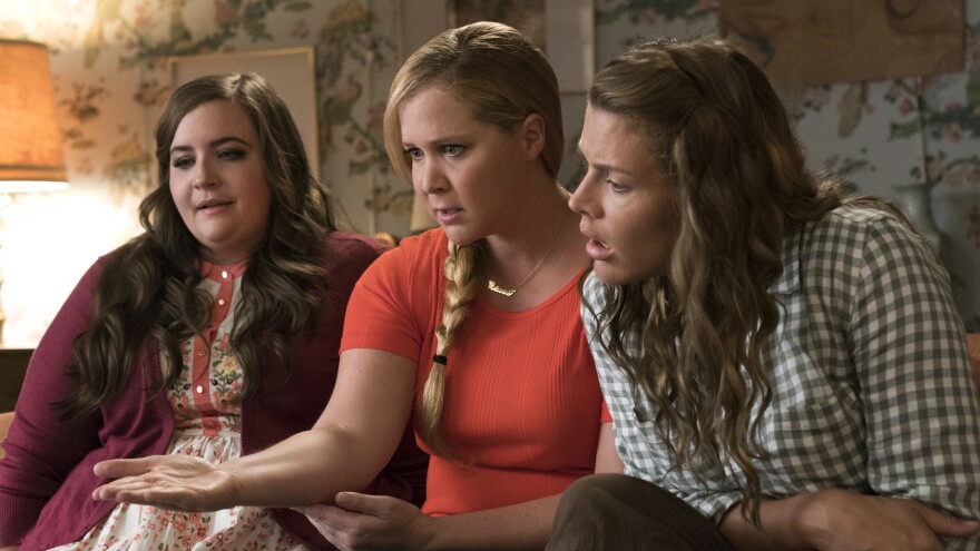 Aidy Bryant (left) and Busy Phillips play best friends to Schumer's Renee in the almost-reverse-makeover movie.
