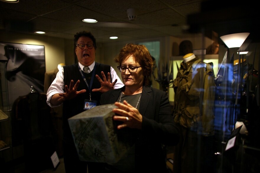 Randall Thropp, a Paramount archivist, recoils in mock fear from the power of the AllSpark as set decorator Rosemary Brandenburg takes it from the glass case. The AllSpark was used as a prop in <em>Transformers; </em>it may have another life in an upcoming sequel.