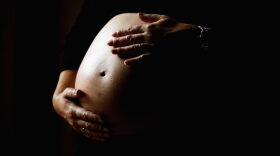 A pregnant woman holds her stomach in Sydney, Australia. 