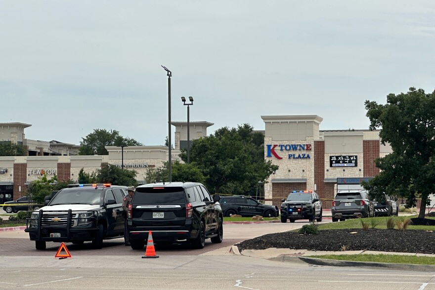 Law enforcement cars parked in a plaza with a sign that reads "K Towne Plaza."