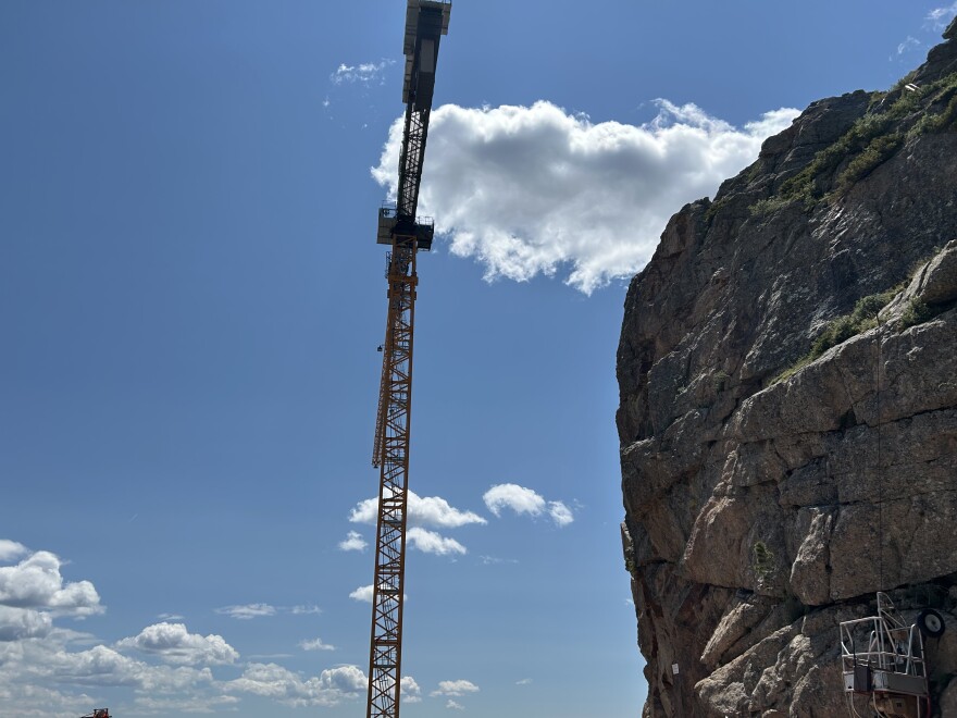 The crane stands over the mountain summit
