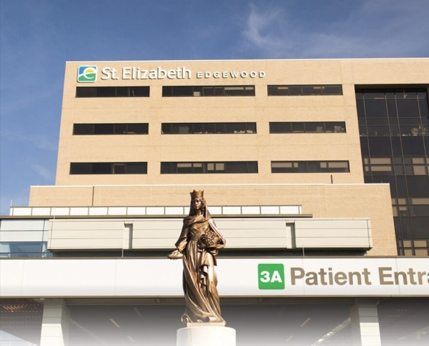 a statue of a woman in a robe and a crown stands in front of a building labeled "patient entrance" 