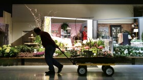 A worker pulls a wagon past a "his and hers" garden theme set at the Northwest Flower & Garden Show Tuesday, Feb. 19, 2013, in Seattle.