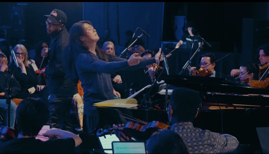An image of JooWan Kim conducting an orchestra
