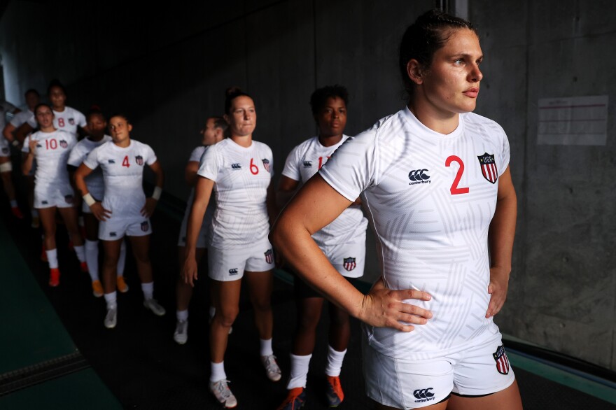 A photo showing a group of people standing in a tunnel wearing white t-shirt and short uniforms.