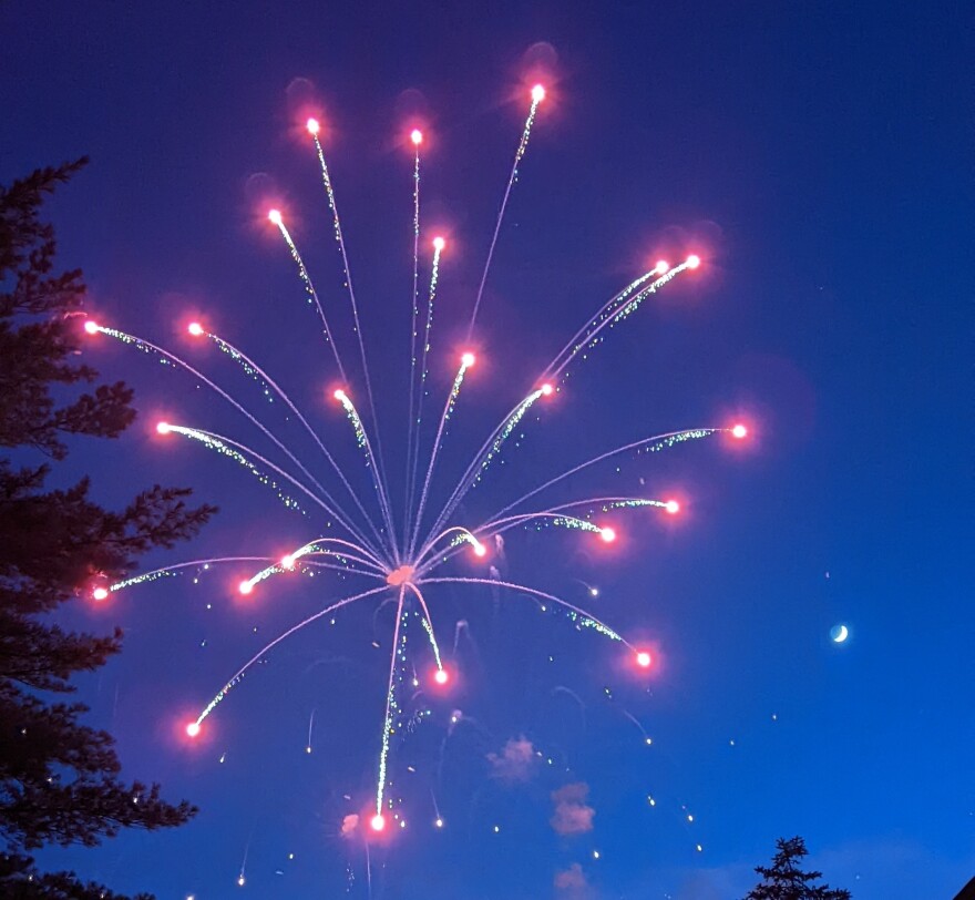 A starshell explodes in the night sky.