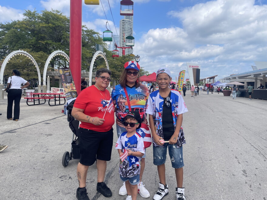 The Vásquez family attends the Puerto Rican Festival of Wisconsin in Milwaukee on Sept. 12, 2026. Four-year-old Mario, front, was upset because he'd smudged a temporary tattoo on his hand of the Puerto Rican flag. He was otherwise having a great time, he assured his grandma, Luz (center).