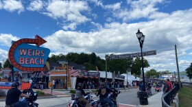 Bikers in front of Weirs Beach sign at the 2021 Laconia Bike Week.