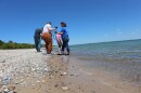 Scot and Jennifer Wack and their son Alden look for Petoskey stones on a Leelanau Peninsula beach with On Hand producer April Van Buren. The honeycomb pattern of Petoskey stones is clearer when the stone is wet, so looking along the water’s edge and in the shallow waters of the beach give you a better chance of spotting one.