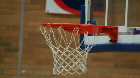 Indoor basketball hoop against a brick background