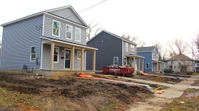 Row of three two story houses under construction.