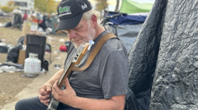 Kelly Wayne Boyer plays his guitar outside his tent in Chico, Calif. on Nov. 15, 2023. He said it was just given to him by a friend a few days ago.