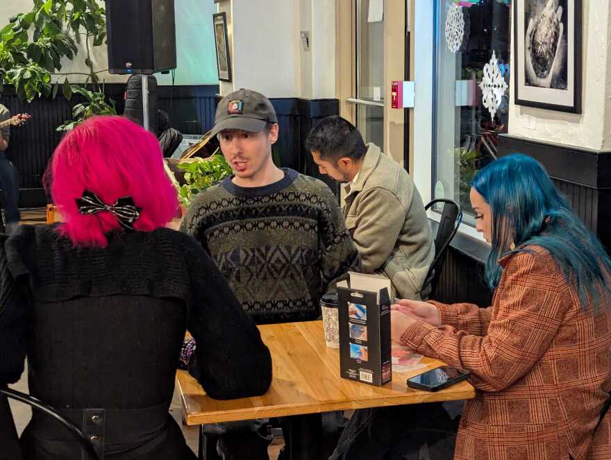 In addition to emceeing the open mic, host Austin Milby spends the evening chatting, joking and getting to know people in the audience at Cure Coffeehouse.