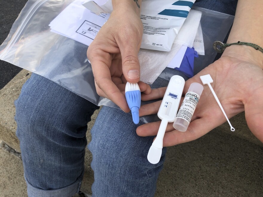 Solutions Oriented Addiction Response organizer Brooke Parker displays an HIV testing kit in Charleston, W.Va., on March 9, 2021.