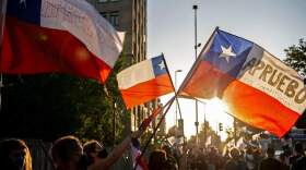 People with Chilean flags take part in a rally in support of amending the constitution established under the military rule (1973-90) of General Augusto Pinochet, ahead of Sunday's referendum, in Santiago, on October 22, 2020.  ( MARTIN BERNETTI/AFP via Getty Images)